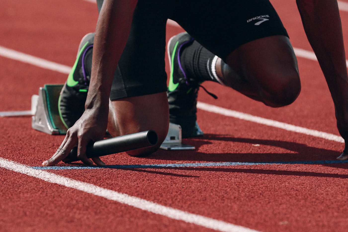 Sprinter in starting blocks on track, close-up detail